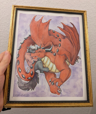 Framed hand drawing of a skunk in a hoodie hugging a large red dragon
