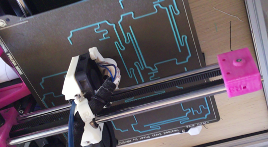 a downwards facing view of my 3d printer, printing seven battery cages. each cage is a spindly little thing, consisting mostly of thin, springy curves. the filament is cyan coloured.