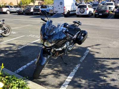 A black 2008 Moto Guzzi Norge 1200 motorcycle sitting in a motorcycle parking spot.