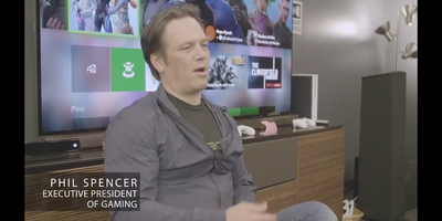 screenshot showing a person in front of a large screen with an xbox attached, subtitled "Phil Spencer, executive president of gaming"