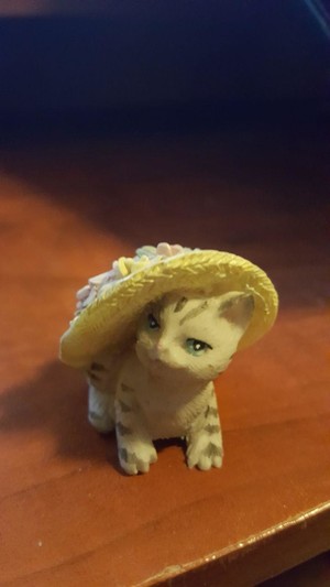 A little cat figurine in a sunhat