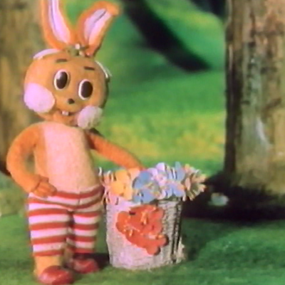 a rabbit in a pair of red and white striped pants, with red shoes standing next to an egg basket.