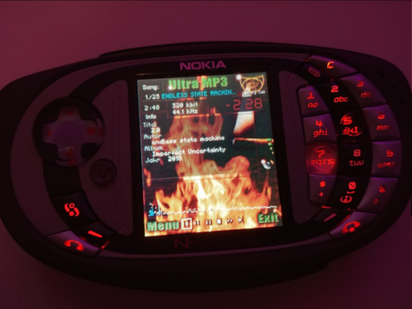 a music player on an N-Gage QD phone, the background is flames and it says "Ultra MP3" at the top