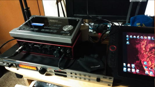 A messy desktop containing a Roland SD-50 sitting atop a Focusrite Scarlett 18i8 Audio Interface, which is sitting on top of a Roland XV-5050. All placed next to an XP-Pen Artiat Pro 15.6 drawing tablet, and in front of a power strip and a decommissioned HP 1280x1024 monitor.
