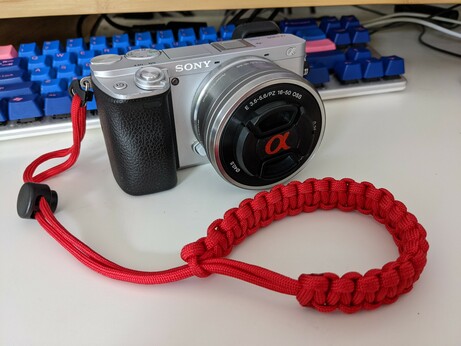 a Sony Alpha 6300 with a red paracord wrist band