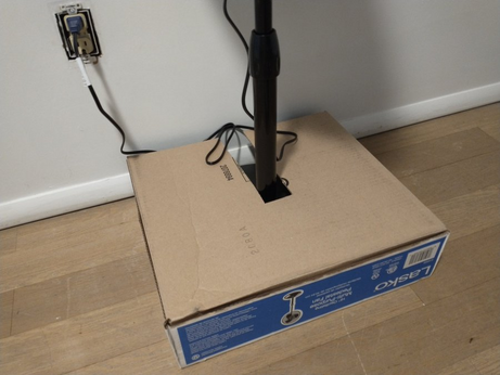 Cardboard box surrounding base of fan.