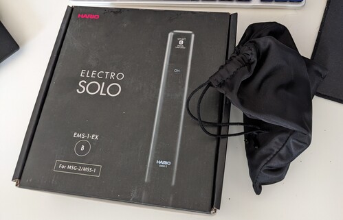 a box with a picture of a black elongated object on it and the words "electro solo", with a small Hario logo in the corner, there's a black fabric bag next to it