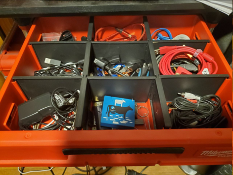 A compartmentalized drawer filled with cables and other miscellaneous PC/electronics bullshit