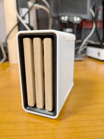 a little white 3d printed PC case with wooden slats (light oak wood) in the front (with a black insert)